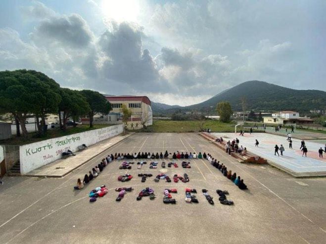 Μαθητές γράφουν συνθήματα με τις τσάντες τους για τα θύματα των Τεμπών